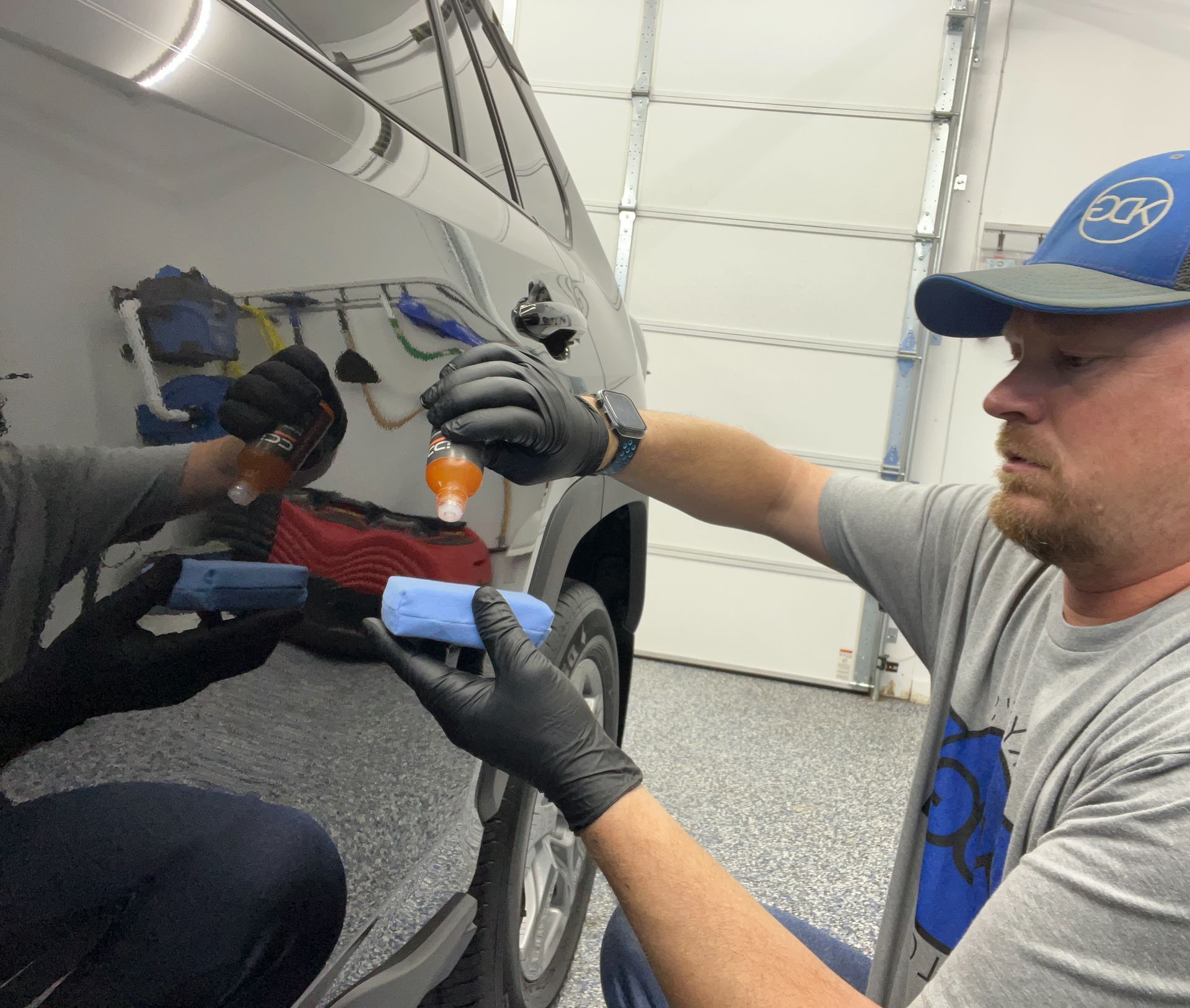 Gloved detailer working on a car headlight at Kyle's Detail Garage